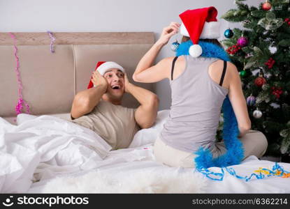 Young happy family celebrating christmas in bed