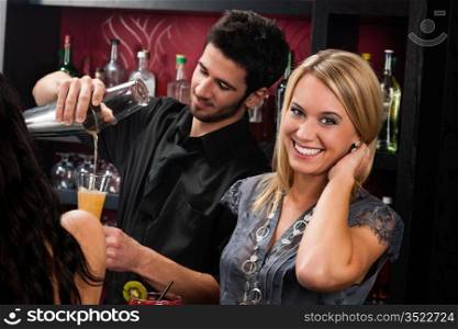Young happy girl at cocktail bar bartender mixing drink