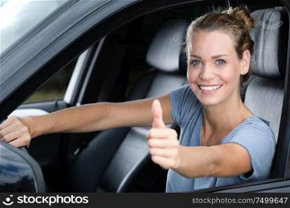 young happy girl doing thumbs up in the car