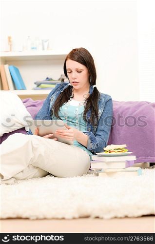 Young happy girl hold touchscreen tablet computer in student apartment