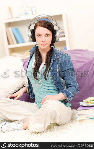 Young happy girl relax listen to music in student apartment