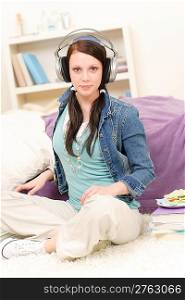 Young happy girl relax listen to music in student apartment