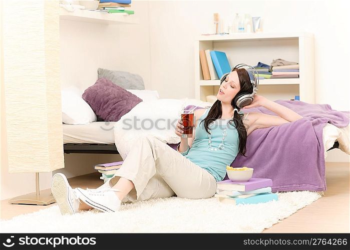 Young happy girl relax listen to music in student apartment