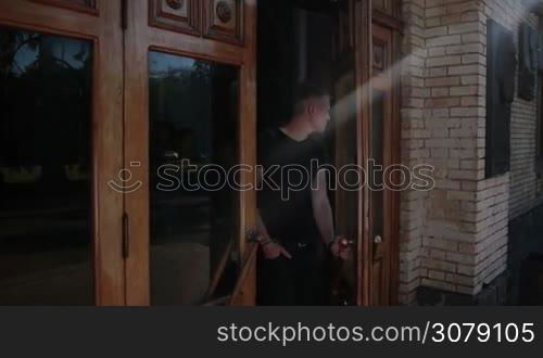 Young happy group of college friends going out from university after finishing class. Cheerful students walking out from building after studying and chatting. Slow motion. Steadicam stabilized shot.