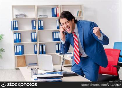 Young happy male employee in the office