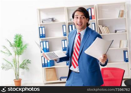 Young happy male employee in the office . Young happy male employee in the office