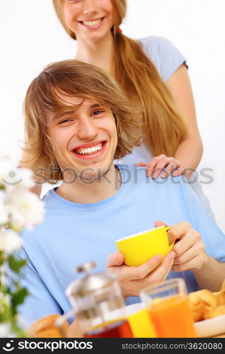 Young happy man drinking tea at home