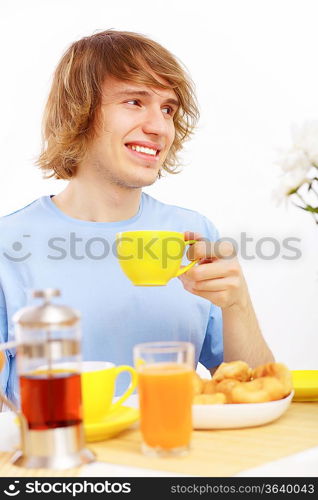 Young happy man drinking tea at home