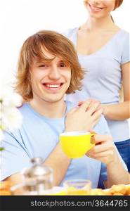 Young happy man drinking tea at home