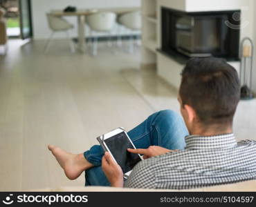 young happy man on sofa using tablet computer at luxury home