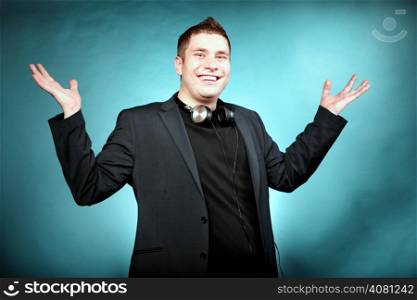 Young happy man student music lover with headphones blue background