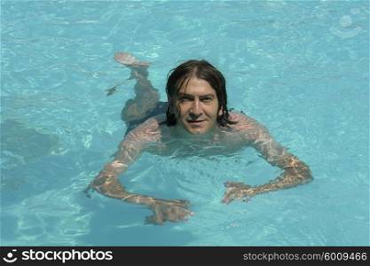 young happy man swimming at the pool