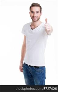 Young happy man with thumbs up sign in casuals isolated on white background.