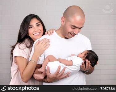 Young happy parents looking on their little newborn baby, having fun at home, enjoying life, new loving family concept