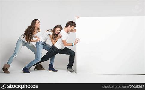 Young happy people pushing white board