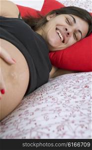 young happy pregnant woman in bed