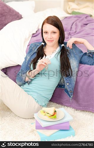 Young happy student relax have fresh sandwich in student apartment