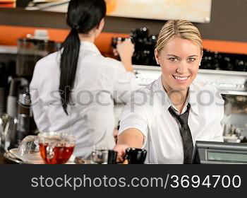 Young happy waitress cashier giving coffee in cafe