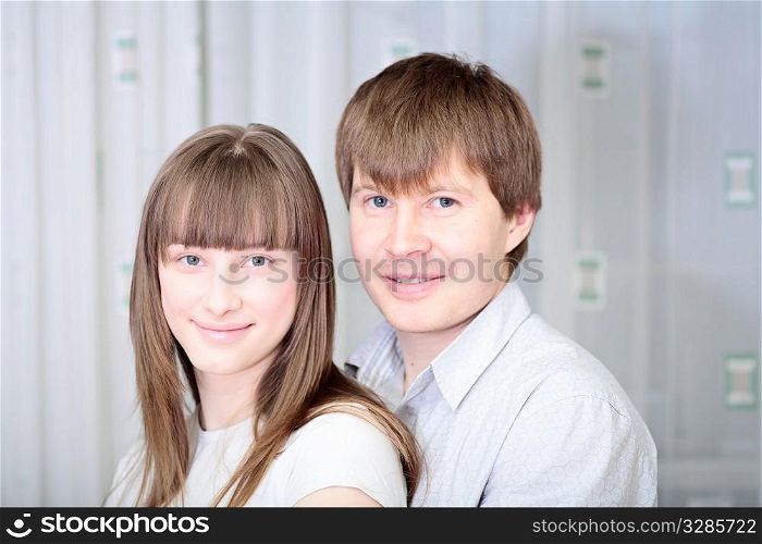 young happy white couple in jeans embracing
