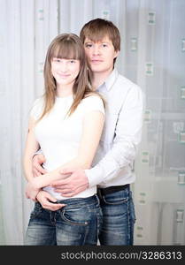 young happy white couple in jeans embracing