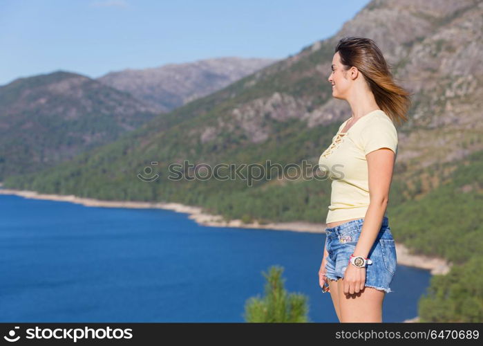 Young happy woman at the mountain, relaxing and enjoying the lake at Geres, Portuguese National Park. girl enjoying the lake