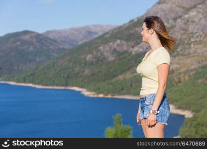Young happy woman at the mountain, relaxing and enjoying the lake at Geres, Portuguese National Park. girl enjoying the lake