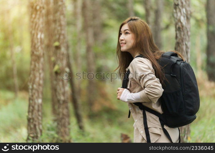 young happy woman carrying a backpack travel and walking in the forest