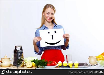 Young happy woman cooking fresh meal at home