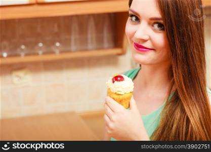 Young happy woman eating delicious gourmet sweet cream cake with fruits on top.. Woman eating delicious cake with sweet cream.