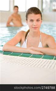 Young happy woman in bikini relax in swimming pool in luxury hotel