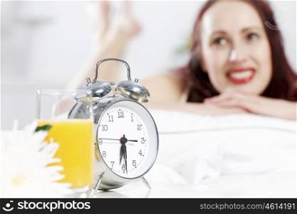 Young happy woman lying in bed and smiling. Good morning