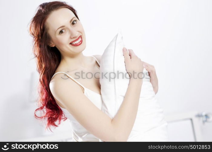 Young happy woman lying in bed and smiling. Good morning