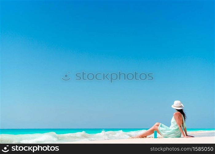 Young happy woman on beach vacation relax and lying at waves. Young woman in bikinin on the beach