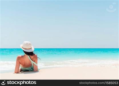Young happy woman on beach vacation. Young fashion woman in green dress on the beach