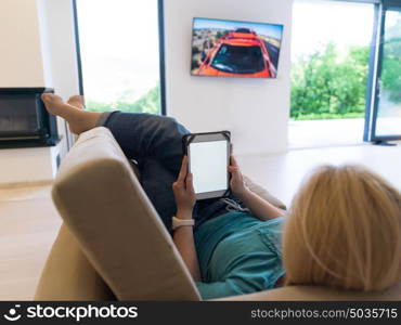 young happy woman on sofa using tablet computer at luxury home