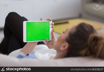 young happy woman on sofa using tablet computer at luxury home