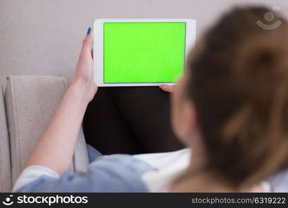 young happy woman on sofa using tablet computer at luxury home