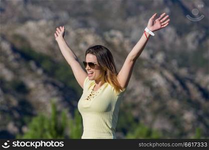 Young happy woman on the rock mountain, with open arms at Geres, Portuguese National Park