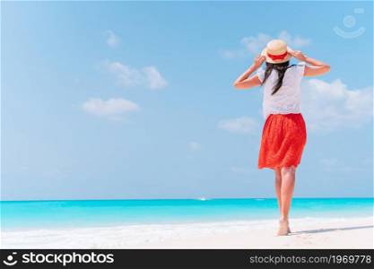 Young happy woman on white beach. Happy girl background the blue sky and turquoise water in the sea. Young beautiful woman having fun on tropical seashore. Happy girl background the blue sky and turquoise water in the sea