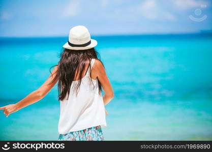 Young happy woman on white beach walking. Young beautiful woman on tropical seashore.. Happy girl background the blue sky and turquoise water in the sea