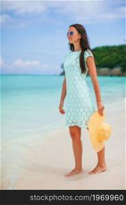 Young happy woman on white beach walking. Young beautiful woman on tropical seashore.. Happy girl background the blue sky and turquoise water in the sea