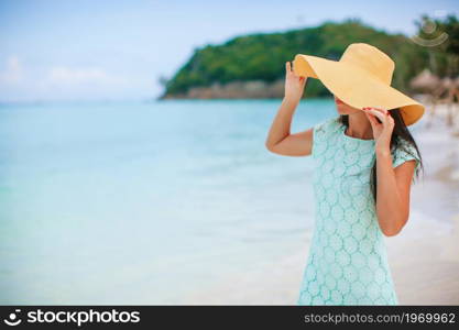 Young happy woman on white beach walking. Young beautiful woman on tropical seashore.. Happy girl background the blue sky and turquoise water in the sea