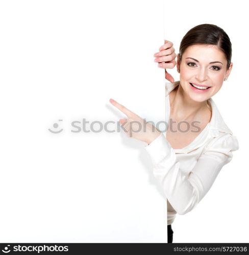 Young happy woman points on the white blank banner - isolated on white background.