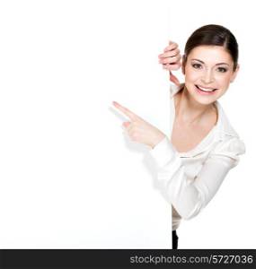 Young happy woman points on the white blank banner - isolated on white background.