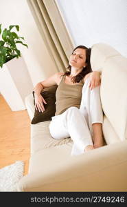 Young happy woman relax lying down on sofa in lounge