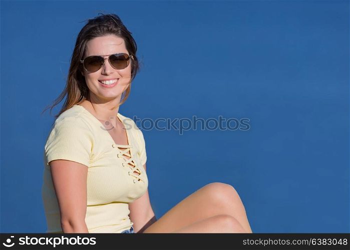 Young happy woman sitting on the rock mountain, relaxing and enjoying the lake at Geres, Portuguese National Park