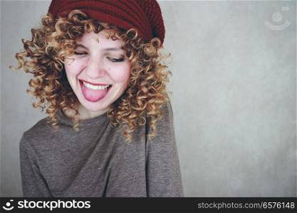 Young happy woman sticking out her tongue