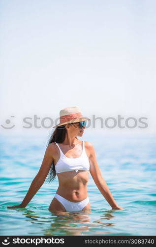 Young happy woman swim in turquoise water in the sea. Happy girl background the blue sky and turquoise water in the sea