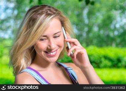 Young happy woman talking on the phone outdoors