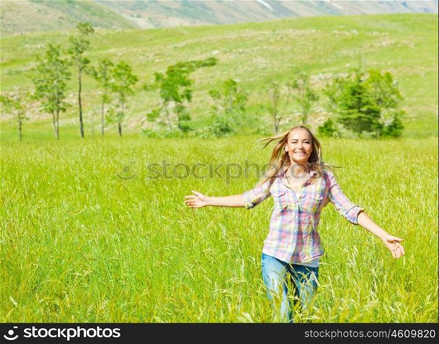 Young happy woman walking on wheat field, cute teen runs on green grass field, carefree girl enjoying peaceful countryside nature, beautiful smiling female have recreation in park, freedom concept